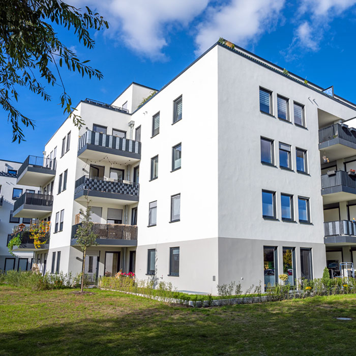 Mehrfamilienhaus mit Balkonen und Grünanlage unter professioneller Immobilienverwaltung